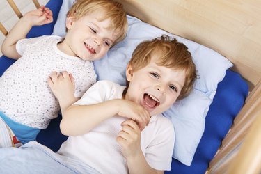 Two little toddler boys having fun and fighting