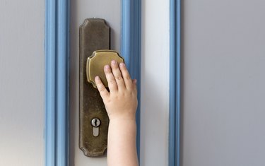 Little child hand on the door handle