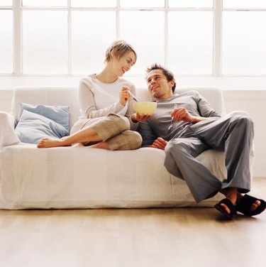 low angle view of a couple sitting on a couch and eating