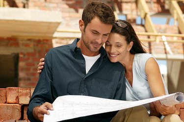 Couple with blueprints at a construction site