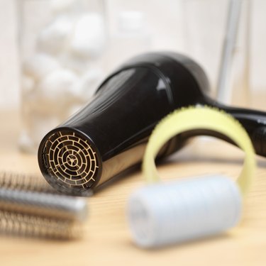Close-up of a hair dryer, hairbrush and curlers