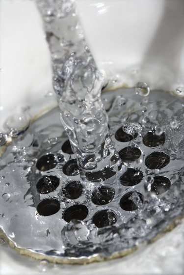 Close-up of water flowing through drain in sink