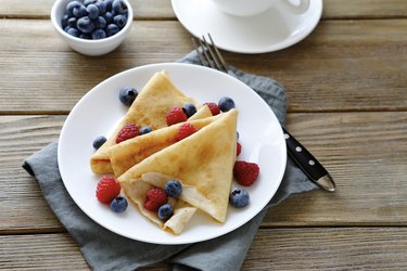 summer crepes with berries on white plates