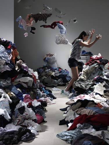 Woman throwing clothes in overflowing laundry room