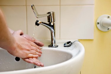 Woman washing hands in sink