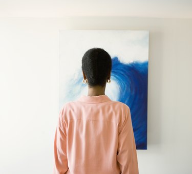 African woman looking at painting