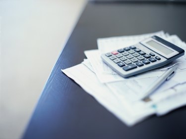 close-up of a calculator and a pen on paper