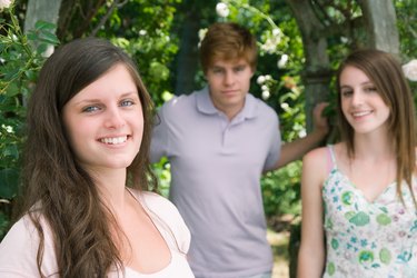 Smiling girl with others outdoors by arbor