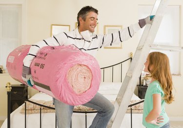 Man and daughter with bundle of roof insulation