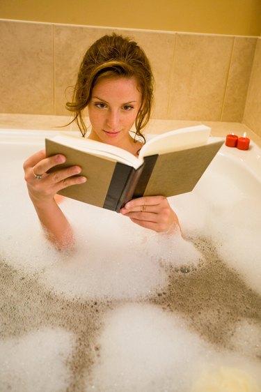 Woman reading in bathtub