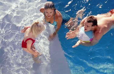 Parents teaching daughter how to swim