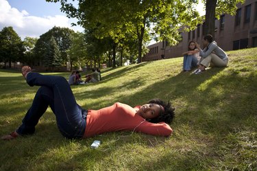 student laying on grass