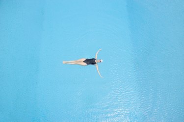 Woman floating in swimming pool