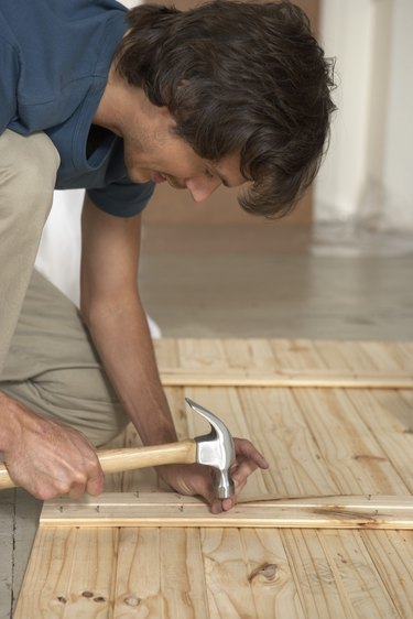 Man hammering nail into lumber