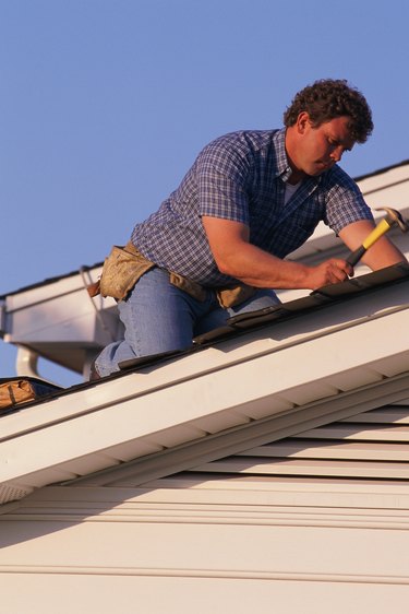 Man putting shingles on roof