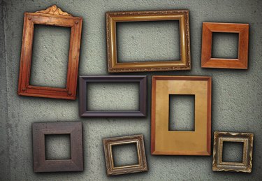 lots of picture frames hung on green wall