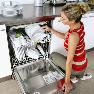 Woman Washing Dishes In Kitchen Sink by George Marks