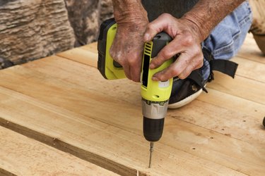 Carpenter's hands using cordless power drill