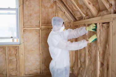 Builder filling walls with insulation.