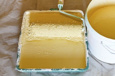 roller brush and bucket with yellow paint