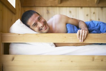 Young man waking up in bunk bed