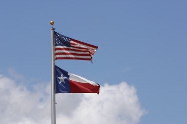 American flag and state flag of Texas in sky