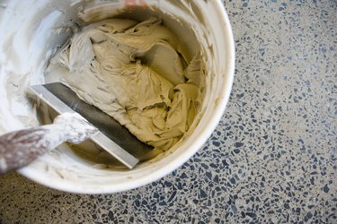 Drywall knife in bucket of joint compound