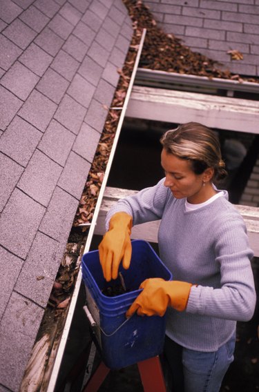 Woman Cleaning out Rain Gutters