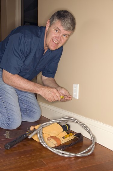 Man working on electrical outlet