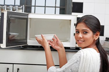 A young woman using a oven