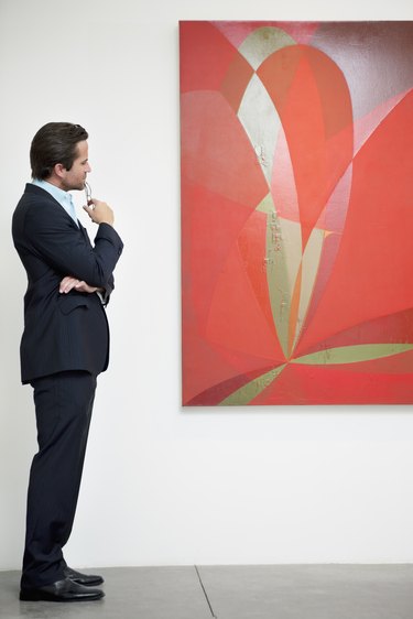 Side view of a man looking intensely towards painting