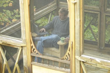 Man relaxing on porch with laptop computer