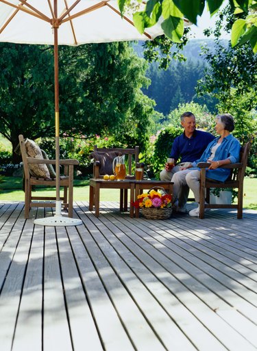 Mature couple sitting on deck drinking iced tea