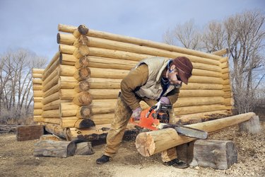 Man building log cabin