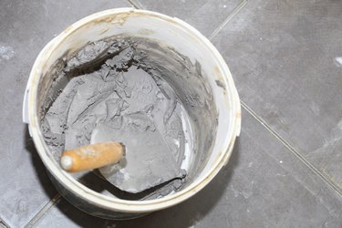 Dirty trowel and bucket on building site. Renovation at home