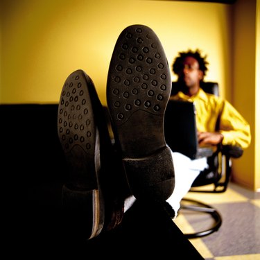 Close-up of shoe soles, man with feet up
