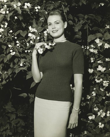Woman posing at blooming jasmine bush, (B&W), (Portrait)