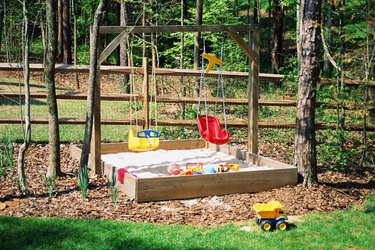 Backyard with a child's sandbox and toys.