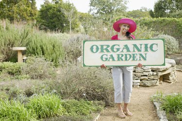 Woman with an organic garden sign