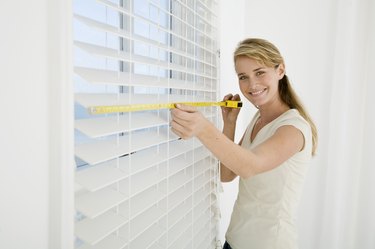 Woman measuring window blinds