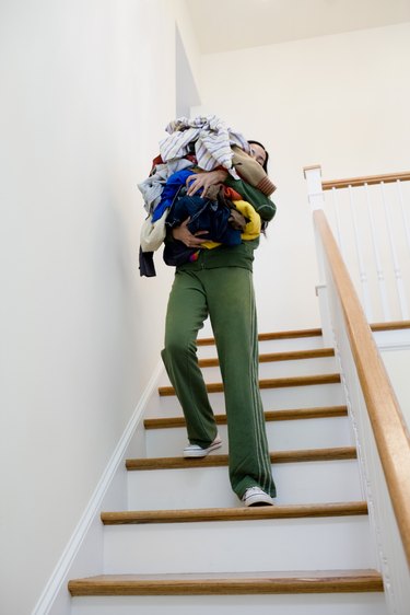 Woman carrying laundry down stairs