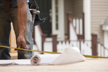 Hispanic carpenter taking a measure with his plans