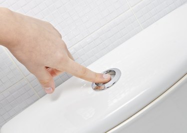 finger pushing button and flushing toilet