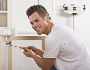 Smiling Man Fixing Cabinet Door