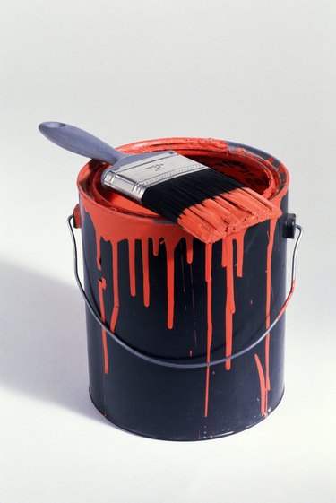 Can of red paint with brush