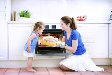 Mother and baby daughter cooking a pie