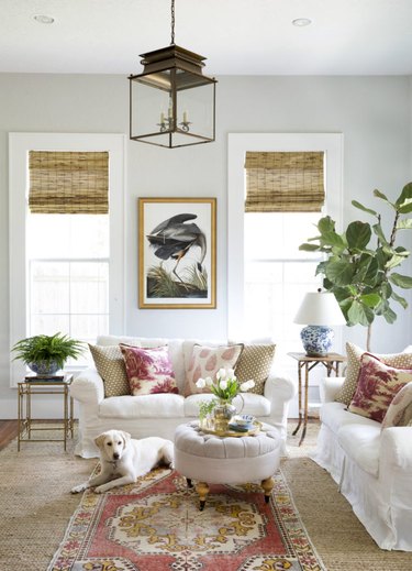 Living room with white couches and bronze pendant light fixture.