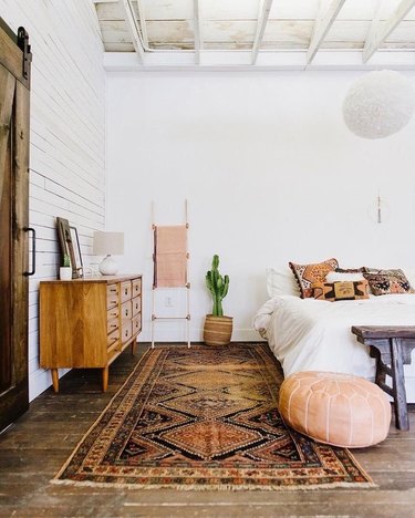 A bohemian meets midcentury bedroom with large kilim rug