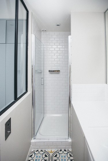 Photo of bathroom with narrow walk-in shower.