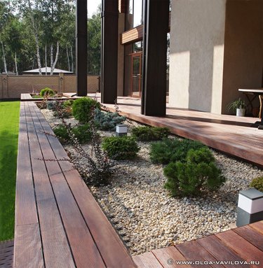 wooden deck with rectangular cutout shrub and rock garden